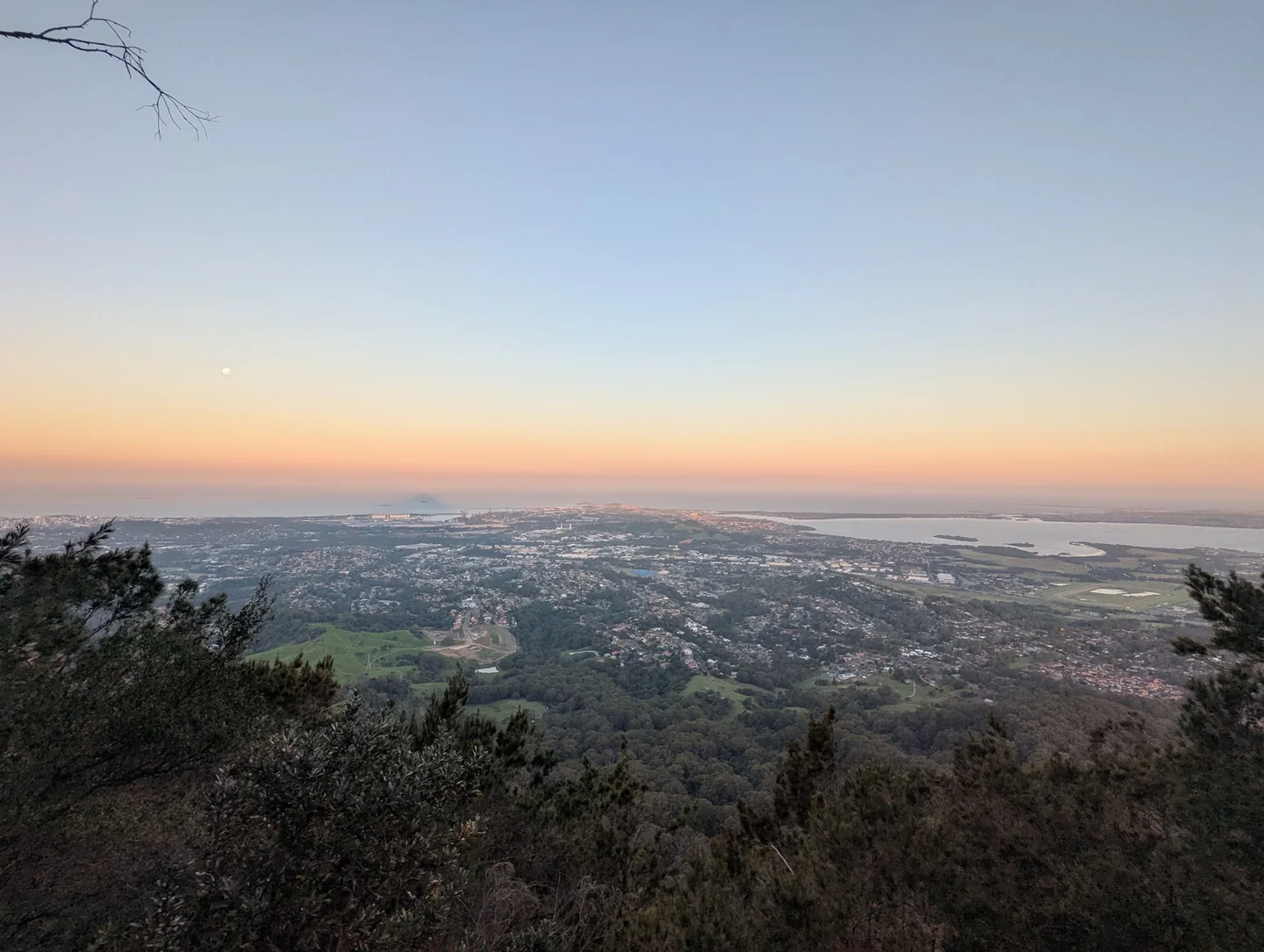 The southern Illawarra at sunset, seen from the escarpment, with homes, industry, lake and ocean below